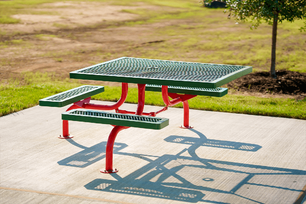 Surface mount commercial picnic table securely bolted to a concrete pad providing stability for parks, patios, and public outdoor seating areas